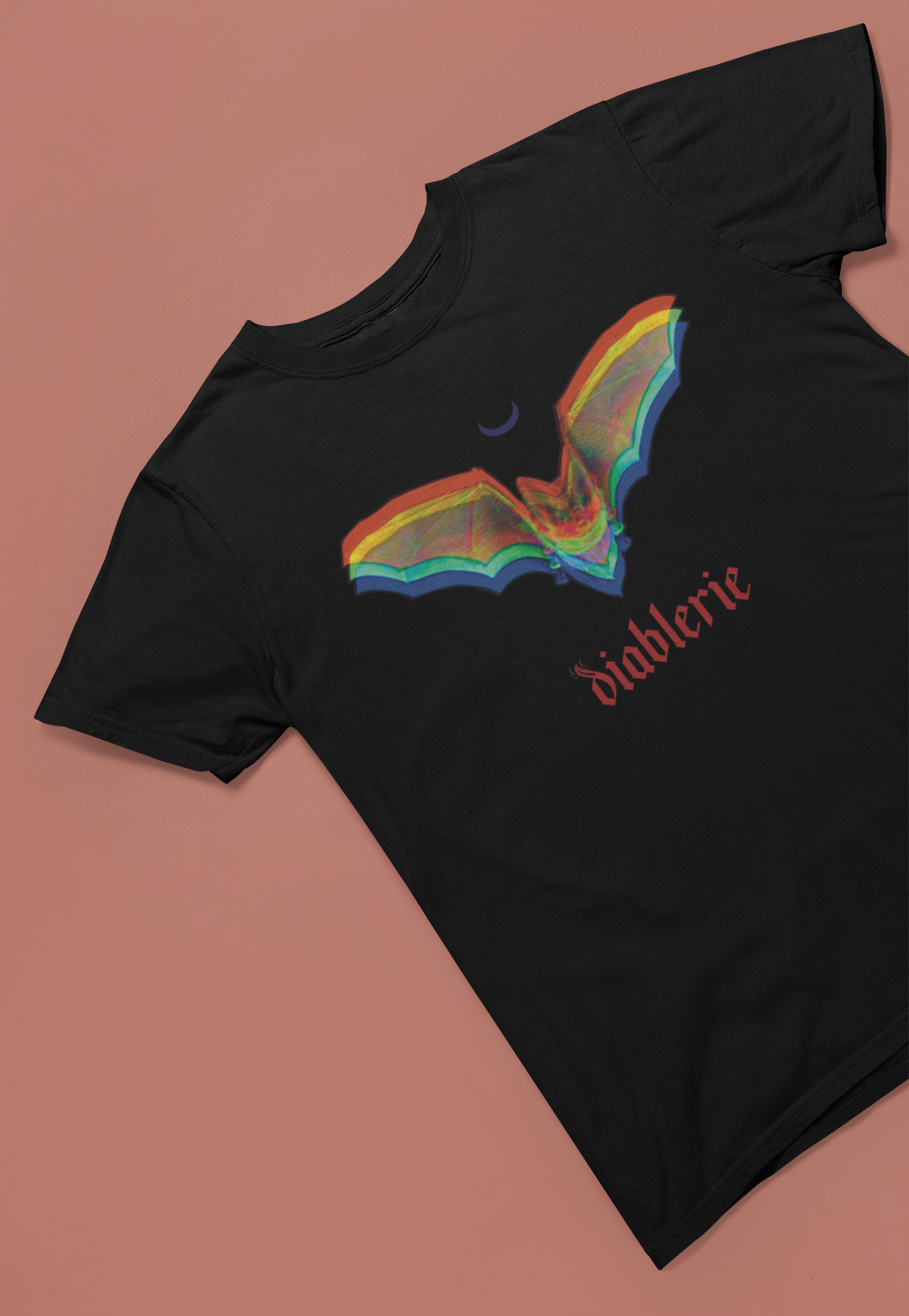 Black t-shirt with RGB anaglyph bat graphic, displayed flat on a warm brown surface