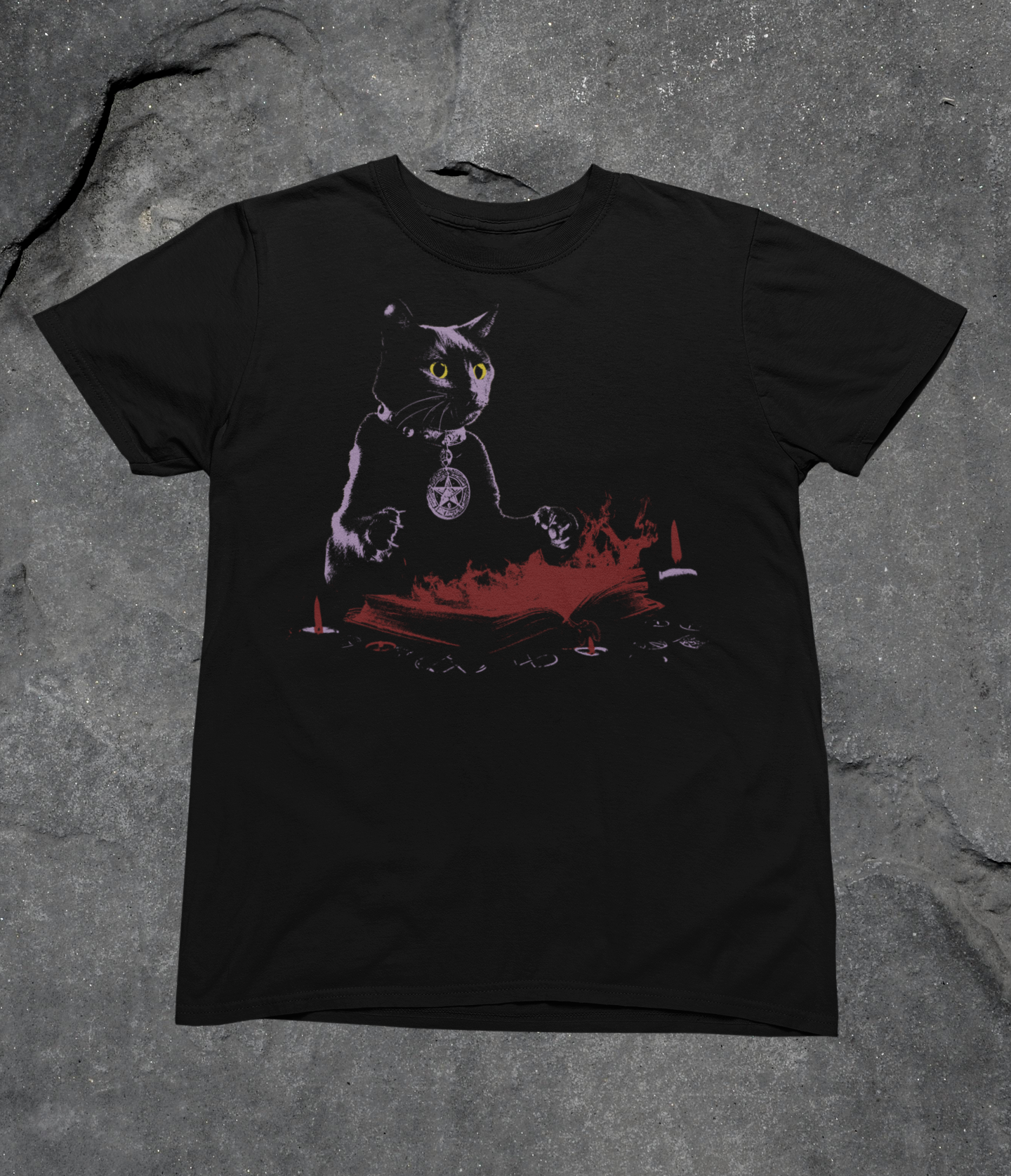 Dark Arts black cat graphic tee laid flat on a textured grey surface, showing the full front design.
